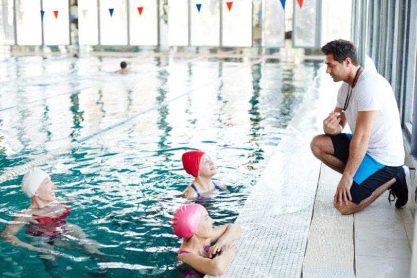 Women in a commercial pool taking swimming lessons